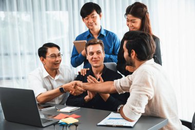 Çeşitli ofis çalışanları stratejik iş pazarlama toplantısı üzerine anlaşma yaptıktan sonra el sıkışıyor. Takım çalışması ve olumlu tutum verimli ve destekleyici bir iş yeri yaratır. Tedbirli