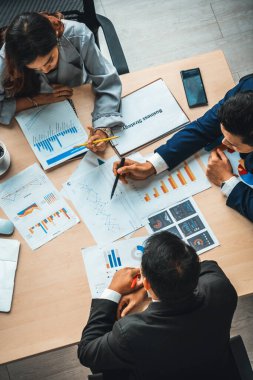 İş adamları grup toplantısı ofiste yukarıdan çekildi. İş kadınları, iş adamları ve ofis çalışanları toplantı masasında proje planlama belgeleriyle takım konferansında çalışıyorlar. Jivy