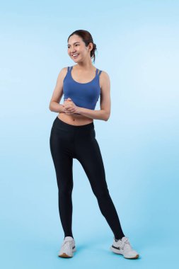 Spor giyim portresindeki tüm vücut Asyalı kadın gülümsüyor ve neşeli bir jest yapıyor. Çekici bir kızla egzersiz yapmak sağlıklı yaşam tarzını sürdürmeye yöneliktir. İzole edilmiş arka plan Vigorous
