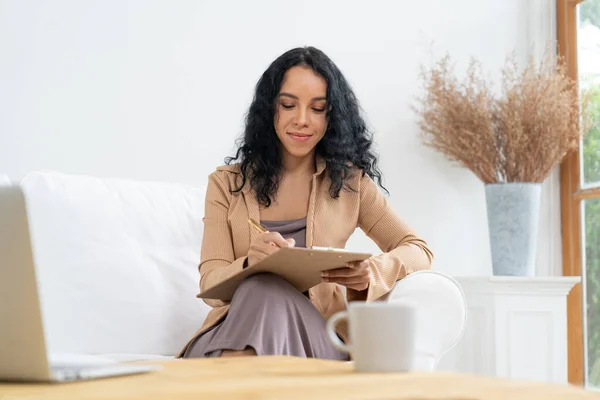 stock image African-American woman using laptop computer for crucial work on internet. Secretary or online content writing working at home.