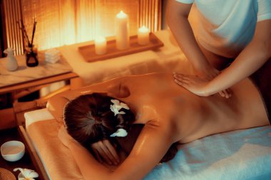 Beyaz kadın müşteri stres önleyici spa masajının keyfini çıkarıyor ve lüks otel ya da otelde sıcak mum ışığında güzellik teniyle eğleniyor. Sessiz.
