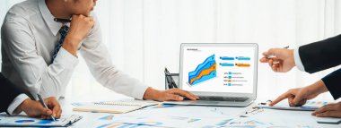 Grup toplantısındaki iş adamları resmi kıyafet paylaşımı fikrine sahipler. Şirketin yaratıcı çalışma alanındaki kar raporunu tartışıyorlar. Grup toplantısı masasında yakın çekim yapmak için. Konuşma .