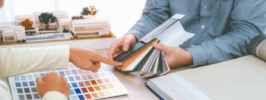 İç mimar takımı, proje yöneticisine renk örnekleri ve mimari modeli toplantı masasında sunar. Yaratıcı çalışma ve tasarım konsepti. Eline odaklan. Değiştirilmiş.