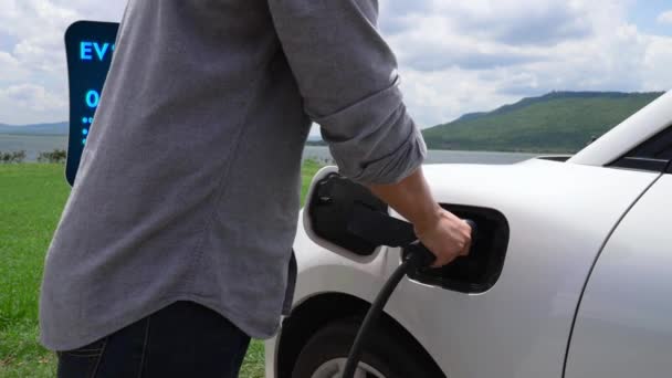Ruční Vložte Smart Nabíječku Elektromobilu Přírodním Jezerním Pozadím Jako Ekologicky — Stock video