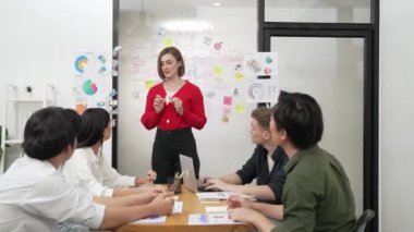 Yetenekli genç ve güzel iş kadını, yaratıcı iş toplantısında yakışıklı yönetici dinlerken zihin haritalama ve istatistiksel grafik kullanarak pazarlama fikrini kendine güvenle sunuyor. Tertemiz..