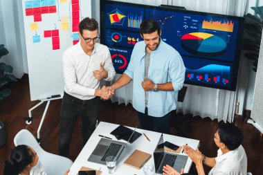 Analist ekip lideri, iş zekası ya da BI gösterge paneli ile FIntech yazılım gücünü kullanarak başarılı veri analizi toplantısından sonra iş arkadaşıyla tokalaştı. Tedbirli