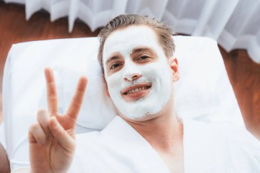 Kaplıca salonunun sakin atmosferi, insan müşterisi modern gün ışığında lüks yüz kremi masajıyla kendini yenileme zevkine kapılıyor. Yüz bakımı ve güzellik konsepti. Sessiz.