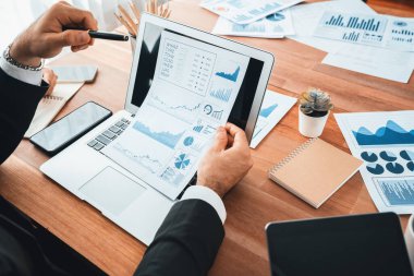 Ofis masasındaki finansal veri raporlarını analiz eden çeşitli bir grup iş analisti. Stratejik pazarlama planlaması için iş istihbarat analizine göre grafikler ve grafikler.