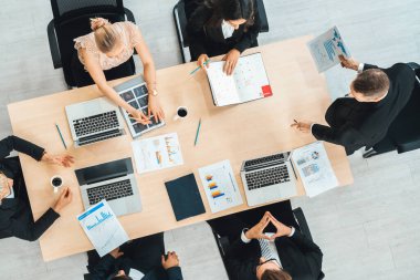 İş adamları grup toplantısı ofiste yukarıdan çekildi. İş kadınları, iş adamları ve ofis çalışanları toplantı masasında proje planlama belgeleriyle takım konferansında çalışıyorlar. Jivy