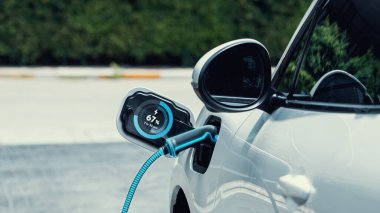 Elektrikli araba şarjı ile EV şarjı, alternatif ve sürdürülebilir enerji kullanılarak şarj edilebilir EV araba için şarj edilebilir akü durum hologramının fütüristik otopark kullanımında.