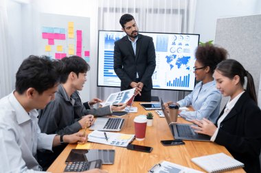 Pazarlama stratejisi için modern toplantıda veri analizi paneli ekranında sunan bir işadamı. Bir grup iş adamıyla konferans odasında iş sunumu. Uyum