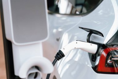 Kapalı EV şarj kolu fişe takıldı veya elektrikli arabaya bağlandı, EV araba aküsünü temiz çevre için sıfır CO2 emisyonu ile alternatif ve sürdürülebilir enerjiyle şarj etti. Kalıcı