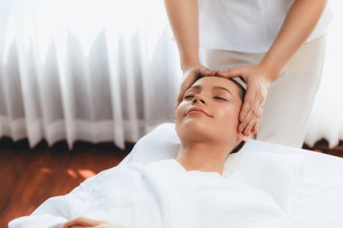Kafkasyalı kadın stres önleyici kafa masajından ve lüks tatil beldesi ya da otel spa salonundaki modern ışık ortamında yüz güzelliği eğlencelerini şımartmaktan hoşlanıyor. Sessiz.