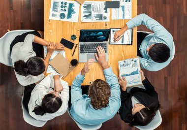 Panorama üst düzey iş analist grubu toplantı masasındaki finansal veri raporunu analiz ediyor. İş zekası analizine göre çizelge ve grafik paneli. Çok titiz.