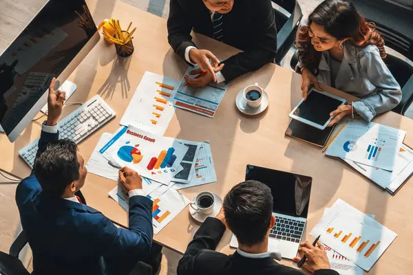 İş adamları grup toplantısı ofiste yukarıdan çekildi. İş kadınları, iş adamları ve ofis çalışanları toplantı masasında proje planlama belgeleriyle takım konferansında çalışıyorlar. Jivy