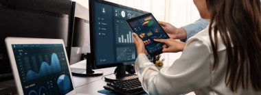 Analizci veri analizi ya da bilgisayar monitöründeki BI gösterge paneli üzerinde çalışıyor. Ticari pazarlama ve strateji planlaması için Fintech 'in şirket ofisindeki finansal verilerini analiz eden iş ekibi. Önde.