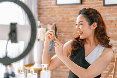 Asyalı Kadın Etkilenen Vlog 'ta canlı yayın yapan videolar sosyal medya ya da blog' un çoğunu oluşturuyor. Kozmetik stüdyosu ışıklandırmalı mutlu genç kız çevrimiçi pazarlama oturumu yayını için.