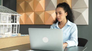 Laptop analizi ev modeli yapısını kullanan İspanyol mimar el mühendislerinin yakın çekimi. Proje yöneticisi dizüstü bilgisayarda yazarken ev modeli inşaatını kontrol ediyor. Tasarım konsepti. Yönlendirici.