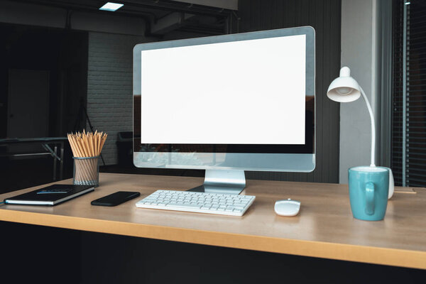 Empty computer monitor screen for design mock up template in modern small office interior or home office. Stylish workplace for creative occupation. Jivy