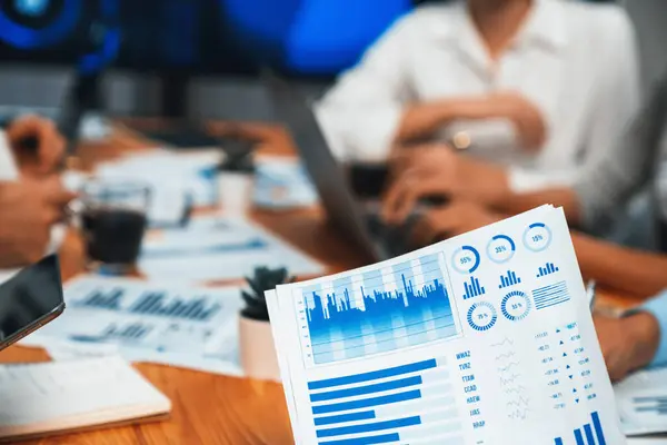 Piles of analyzed financial data dashboard on meeting table with background of business people analyzing data analysis market trend indication for strategic marketing investment plan. Habiliment