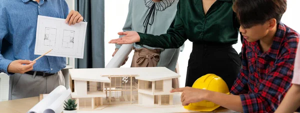 Skilled architect engineer team present house structure to project manager while coworker shows house blueprint. Professional manager discuss about house construction at meeting room Burgeoning.