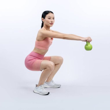 Dinç, enerjik bir kadın izole edilmiş arka planda ağırlık kaldırma egzersizi yapıyor. Genç atletik Asyalı kadın dayanıklılığı ve dayanıklılık eğitimi rutin vücut egzersizi..