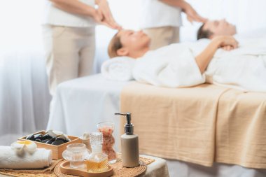 Aromaterapi masajı gündüz atmosferinde ya da spa salonunda bulanık bir kadına odak dekor ve spa aksesuarları kurarak tatil köyünde ya da otel arka planında keyifli aroma spa masajı yapan bir masaj. Sessiz.