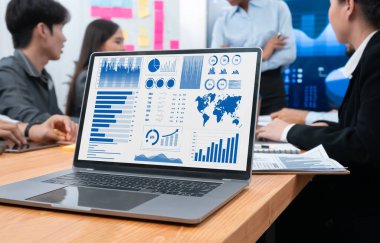 Takım toplantısı veya sunum sırasında iş büyüme stratejisi ve pazarlama göstergesi için veri analizi grafiği ve grafiğini gösteren dizüstü bilgisayardaki dijital finansal BI gösterge paneli. Uyum