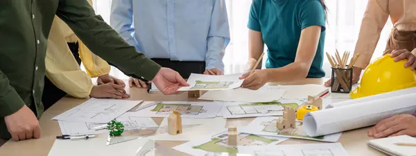 プロの建築家エンジニアチームが木製のブロックと青写真の散乱で会議テーブルの建築プロジェクトについて議論します コンセプトをデザインし 協力します クローズアップ デリネーション — ストック写真