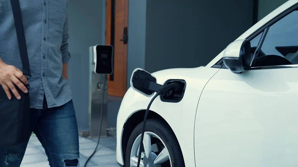 一个人在家里拔掉电动汽车充电器的插头 在进步的生活方式中使用电动汽车的概念有助于清洁和健康的环境 — 图库照片