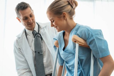 Doktor hastanede koltuk değnekli hastayla ilgileniyor. Fizyoterapist ve bacak yaralanması konsepti. Jivy