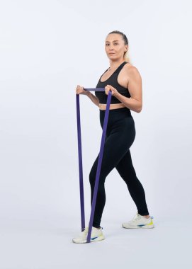 Vücut uzunluğu tam, atletik ve sportif yaşlı kadın izole arka planda fitness direnci bandı var. Emeklilikten sonra sağlıklı, aktif bir fiziğe ve vücut bakımına sahip. Etki