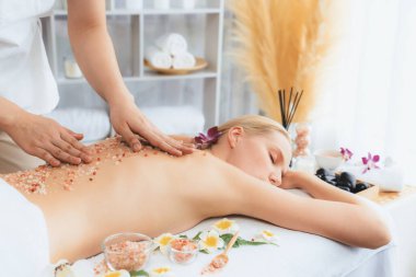 Lüks spa salonunda sıcak mum ışığı atmosferi olan kaplıca tedavisi gören kadın müşteri. Sağlık kaplıcasında güzellik tedavisiyle tuz temizliği. Sessiz.