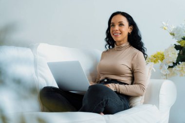 İnternette önemli bir iş için dizüstü bilgisayar kullanan Afro-Amerikalı bir kadın. Evde çalışan sekreter veya çevrimiçi içerik yazma.