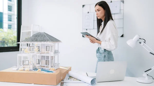 Young Beautiful Caucasian Architect Focus Using Tablet Checks House Model — Stock Photo, Image