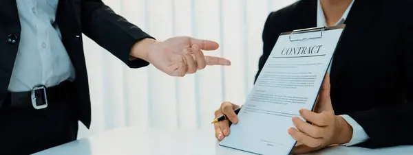 Business executive signing contract agreement document on the bale with the help from company attorney or lawyer service in law firm office. Business investing and finalizing legal processing. Shrewd