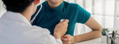 Hasta klinikte ya da hastane ofisinde doktor randevusuna gidiyor. Hastaların nabzını steteskopla kontrol ederken, doktor semptomları muayene ediyor ve teşhis ediyor. Panorama Katı