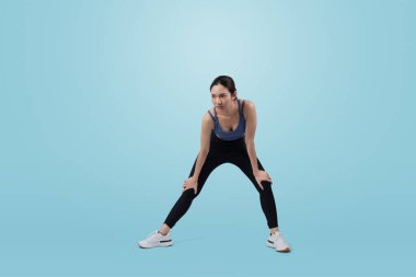 Spor giyim portresindeki tüm vücut Asyalı kadın gülümsüyor ve neşeli bir jest yapıyor. Çekici bir kızla egzersiz yapmak sağlıklı yaşam tarzını sürdürmeye yöneliktir. İzole edilmiş arka plan Vigorous
