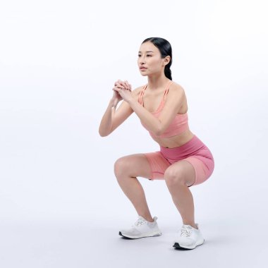 Egzersiz yapan enerjik bir kadın. Genç atletik Asyalı kadın gücü ve dayanıklılık antrenmanı rutin antrenman olarak. Tüm vücut stüdyosu izole edilmiş arka planda çekilmiş..