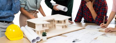 Mimari takım analizi ve ev modeli, plan ve mimari ekipmanlarla toplantı masasında ev inşaatı hakkında beyin fırtınası. Yaratıcı tasarım ve takım çalışması. Filizlenen.