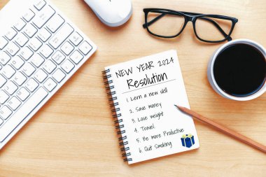 2024 Mutlu Yeni Yıl Kararları Hedef Listesi ve Planları Ayarlama - Yeni yıl hedefleri ve kararları planlama hakkında not defteriyle birlikte iş yeri masası. Değişim ve mutluluk kavramı.