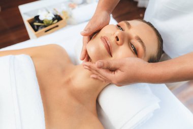 Kafkasyalı kadın stres önleyici kafa masajından ve lüks tatil beldesi ya da otel spa salonundaki modern ışık ortamında yüz güzelliği eğlencelerini şımartmaktan hoşlanıyor. Sessiz.