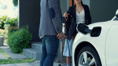 Elektrikli araç şarj istasyonu olan, sağlıklı ve temiz bir çevreyi teşvik eden yenilikçi bir aile kavramı. Sürdürülebilir, temiz enerji teknolojisiyle çalışan elektrikli araç..
