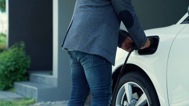 Elektrikli araç şarj istasyonu olan, sağlıklı ve temiz bir çevreyi teşvik eden yenilikçi bir aile kavramı. Sürdürülebilir, temiz enerji teknolojisiyle çalışan elektrikli araç..