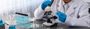 Bilim adamları yeni bir aşı ilacı ya da antibiyotik geliştirmek için mikroskop kullanarak tıbbi laboratuarda kimyasal deney yapıyorlar. Biyoteknoloji laboratuvarı ve tıp araştırma konsepti. Neoterik