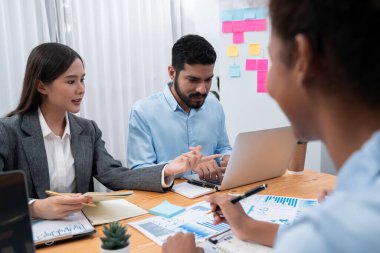 Çok ırklı analist ekibi toplantı masasındaki mali raporu analiz etmek için BI gösterge tablosunu kullanıyor. Çeşitli iş adamlarından oluşan bir grup, FIntech 'in veri analizini başarılı iş pazarlaması için kullanır. Uyum