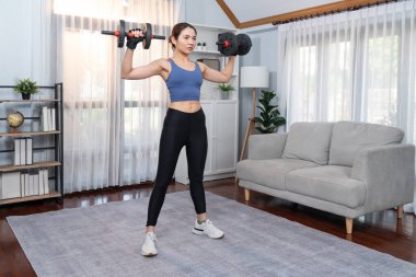 Güçlü enerjik kadın evde halter kaldırma egzersizi yapıyor. Genç atletik Asyalı kadın dayanıklılığı ve dayanıklılık antrenmanı. Ev ödevi olarak..