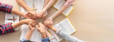 Ahşap kilisede İncil 'in kutsal kitabını tutarken birlikte dua eden bir grup insanın kesilmiş görüntüsü. Umut, din, inanç, Hıristiyanlık ve Tanrı 'nın kutsaması kavramı. Üst Manzara. Filizlenen.