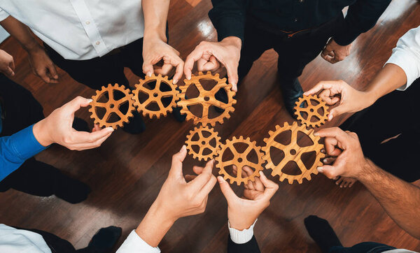 Business team joining cogwheel in circular together symbolize successful group of business partnership and strong collective unity teamwork in community workplace with productive efficiency. Prudent