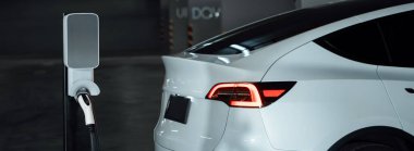Alış veriş merkezinin otoparkında EV elektrikli araba şarjı şehir merkezindeki sürdürülebilirlik yaşam tarzını yeşil, temiz, yeniden şarj edilebilir elektrikli araç iç organları ile gösteriyor.